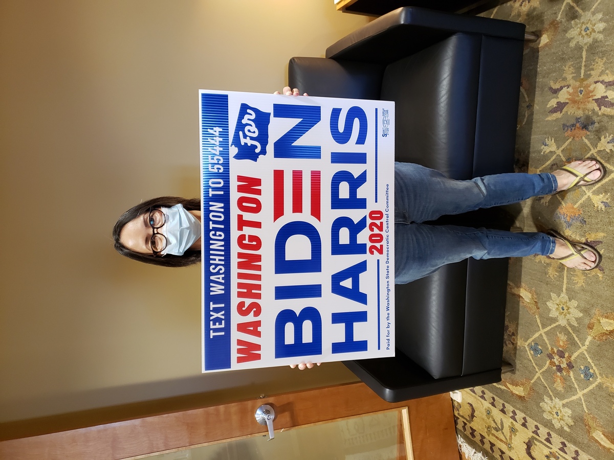 Picture of happy voter with a Biden/Harris Yard Sign in hand.